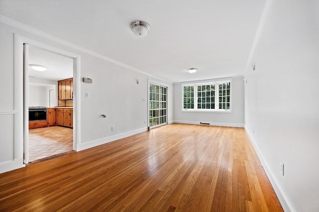 unfurnished living room featuring light wood-type flooring, ornamental molding, and baseboards