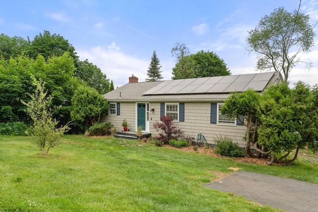 410 Central St, Acton, MA 01720 - ranch-style home featuring a front yard, roof mounted solar panels, a chimney, and a shingled roof
