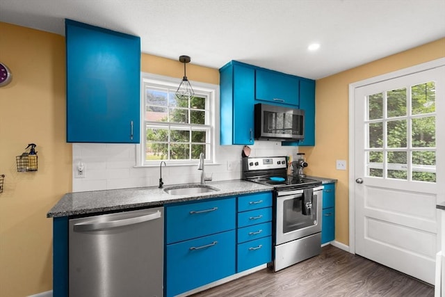 410 Central St, Acton, MA 01720 - kitchen featuring appliances with stainless steel finishes, blue cabinetry, and decorative backsplash