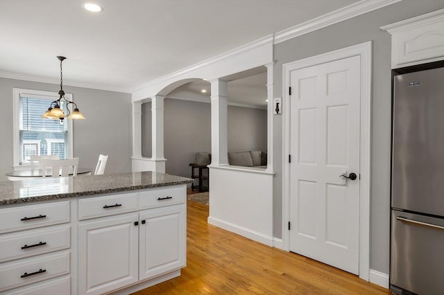 67 Madison St, Amesbury, MA 01913 - kitchen featuring stainless steel fridge, decorative columns, crown molding, light wood-type flooring, and white cabinetry