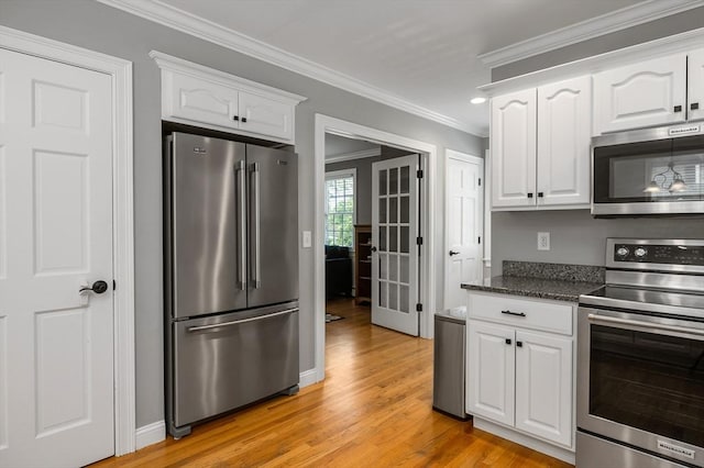 67 Madison St, Amesbury, MA 01913 - kitchen with appliances with stainless steel finishes, white cabinets, light wood-style floors, crown molding, and dark stone counters