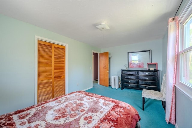 carpeted bedroom with radiator heating unit and a closet