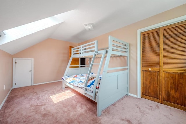 bedroom featuring carpet, vaulted ceiling, baseboards, and a closet