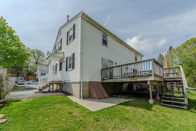 rear view of house with stairs, a lawn, and a wooden deck