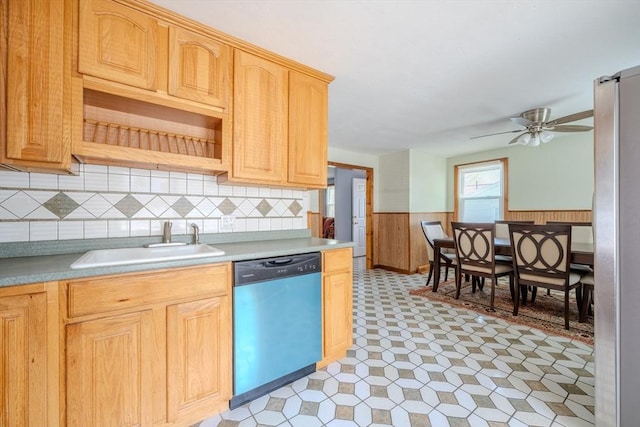 kitchen featuring dishwasher, a sink, wainscoting, freestanding refrigerator, and light countertops