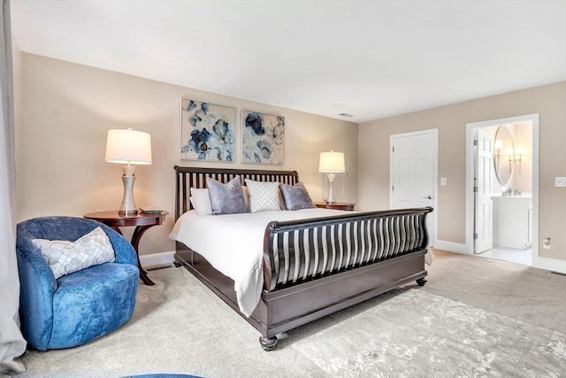 carpeted bedroom featuring ensuite bath