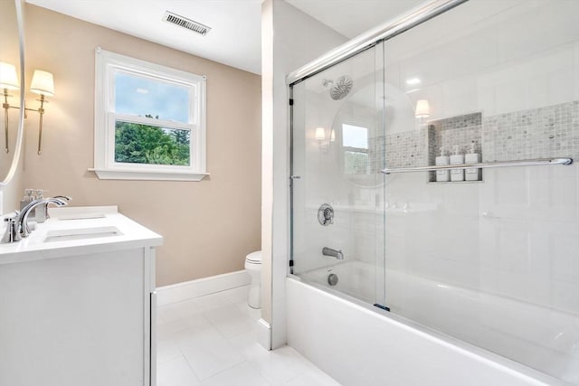 full bathroom with tile patterned flooring, vanity, bath / shower combo with glass door, and toilet