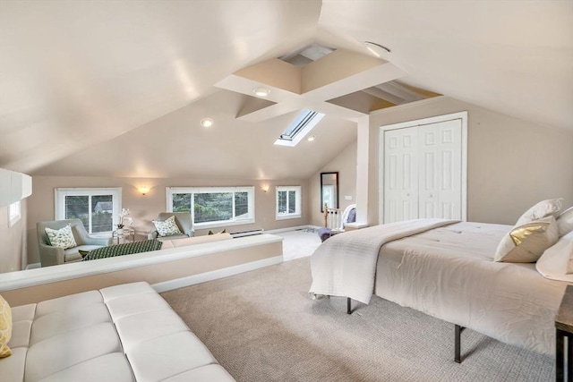 carpeted bedroom featuring a closet and vaulted ceiling with skylight