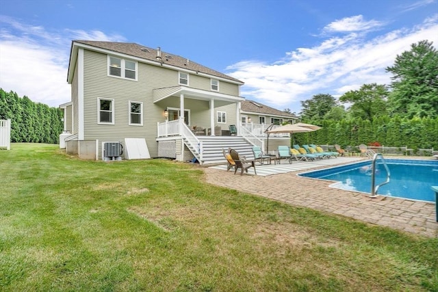 rear view of property featuring a patio, a fenced in pool, central AC, and a lawn