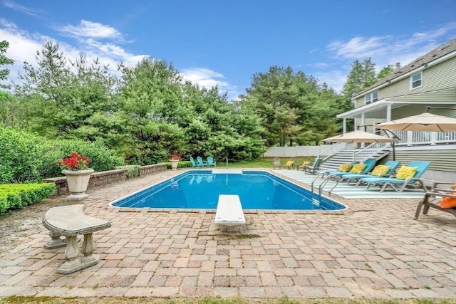 view of pool featuring a diving board and a patio area