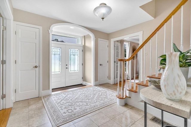72 Rinnock Rd, Fitchburg, MA 01420 - foyer entrance with arched walkways, stairway, light tile patterned flooring, and baseboards