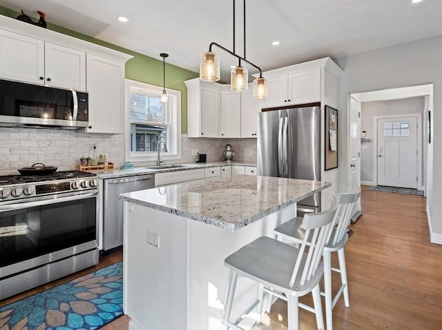 38 Oneil St, Hudson, MA 01749 - kitchen with stainless steel appliances, a sink, white cabinets, light wood-type flooring, and recessed lighting