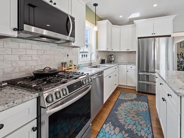 38 Oneil St, Hudson, MA 01749 - kitchen with appliances with stainless steel finishes, a sink, white cabinets, wood finished floors, and recessed lighting
