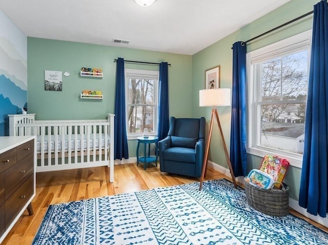 38 Oneil St, Hudson, MA 01749 - bedroom featuring light wood-type flooring, multiple windows, baseboards, and a crib