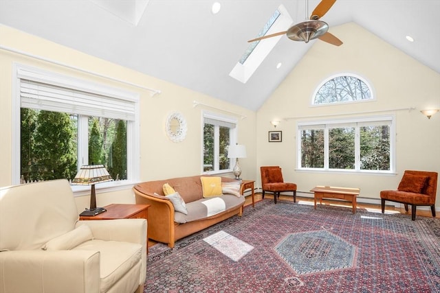 living area with a ceiling fan, a skylight, and high vaulted ceiling