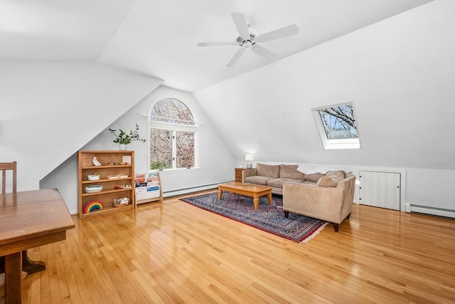 living room featuring baseboard heating, wood-type flooring, a ceiling fan, a baseboard heating unit, and lofted ceiling with skylight