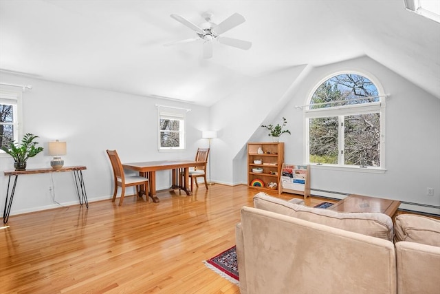 living area featuring ceiling fan, vaulted ceiling, plenty of natural light, and light wood-style flooring