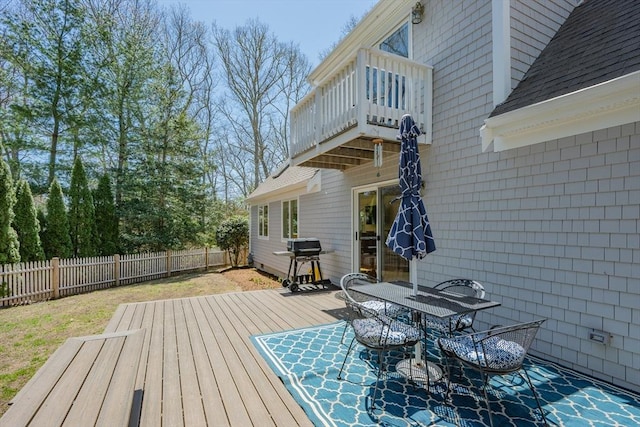 wooden deck with area for grilling, a fenced backyard, and outdoor dining space