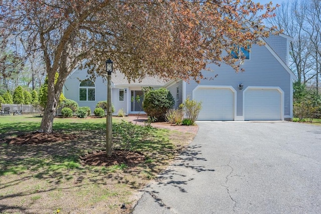 obstructed view of property featuring a garage, driveway, and a front yard