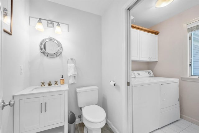 bathroom featuring vanity, a healthy amount of sunlight, toilet, baseboards, and washer and clothes dryer