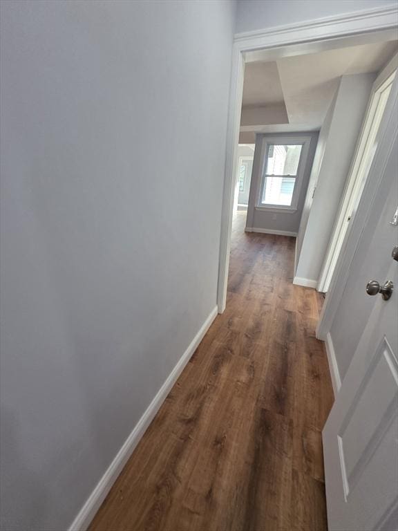 hall featuring baseboards and wood finished floors
