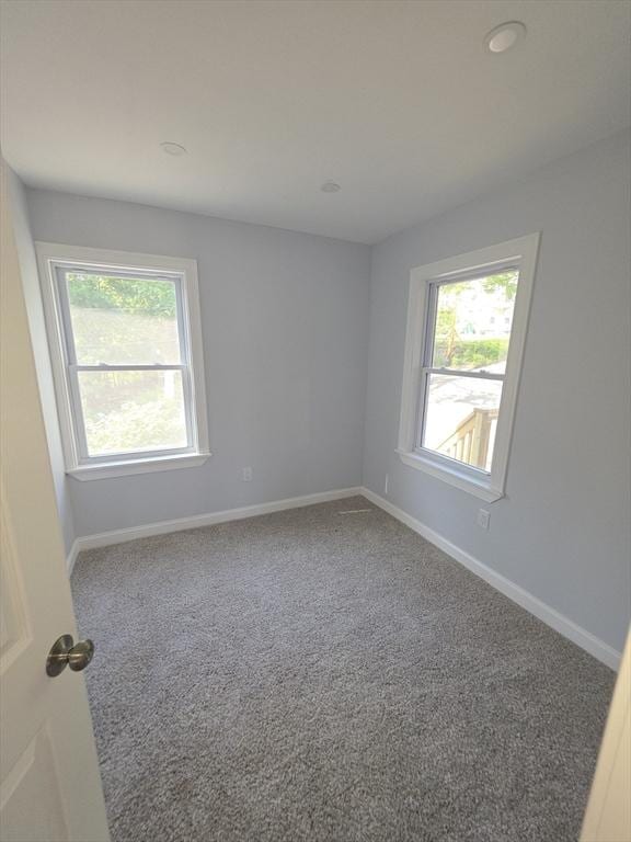 carpeted empty room with plenty of natural light and baseboards