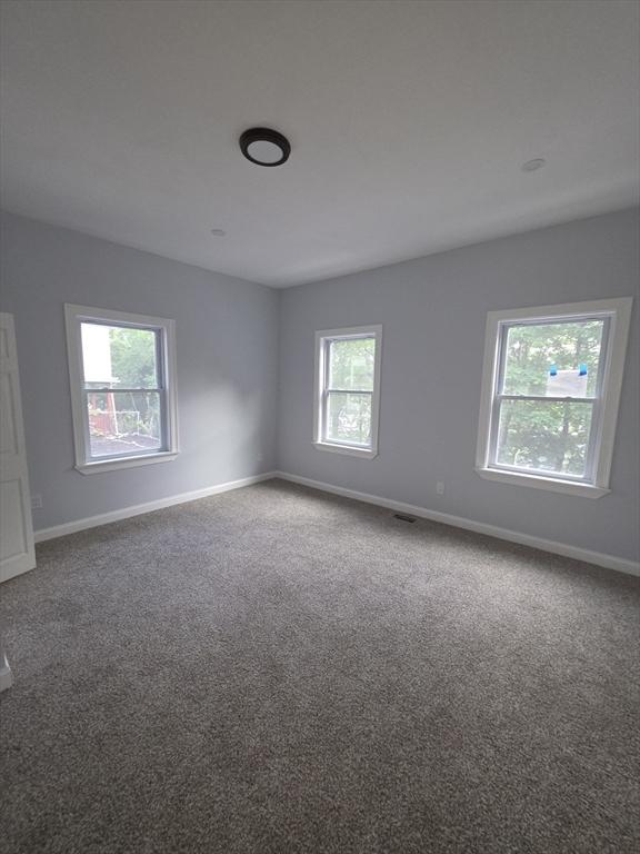 carpeted spare room with baseboards