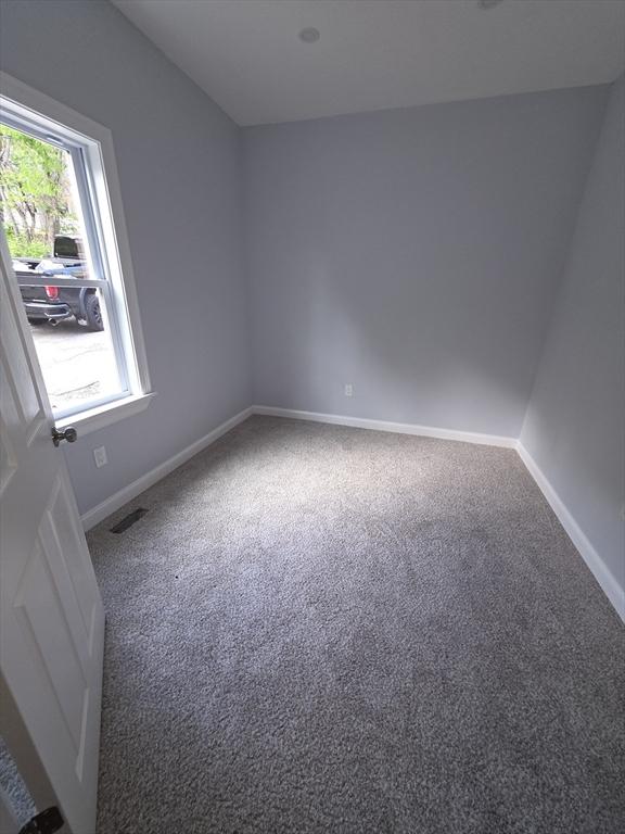 empty room featuring carpet floors and baseboards