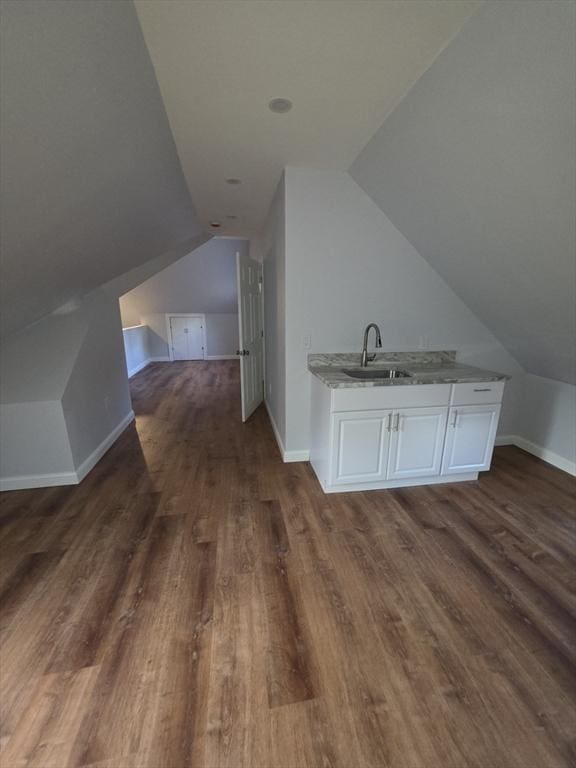 bonus room with a sink, wood finished floors, lofted ceiling, and baseboards