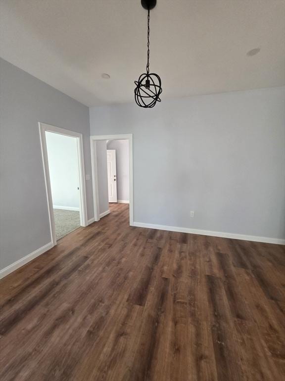 unfurnished dining area with baseboards and dark wood finished floors