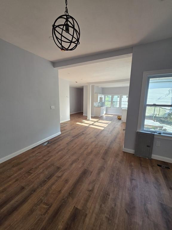 unfurnished dining area with dark wood finished floors and baseboards