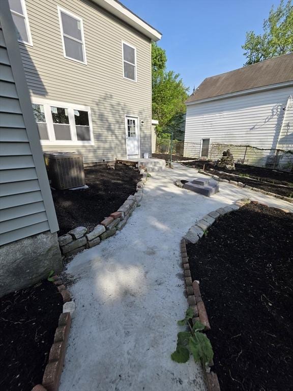 rear view of property with central AC unit, a patio area, and fence