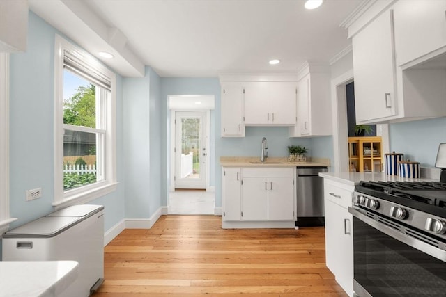 12 Fern St, Chelmsford, MA 01824 - kitchen with stainless steel appliances, light countertops, white cabinetry, light wood-style floors, and recessed lighting