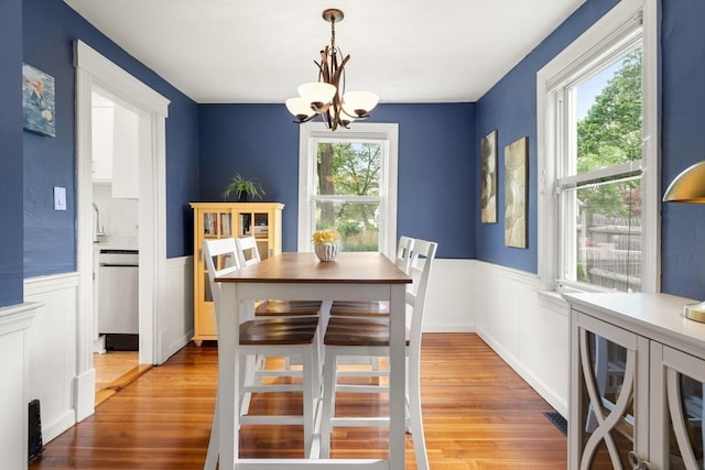 12 Fern St, Chelmsford, MA 01824 - dining room featuring a chandelier, a wainscoted wall, light wood finished floors, and a decorative wall
