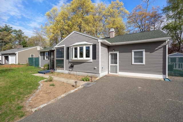 single story home featuring fence, a chimney, and a front lawn