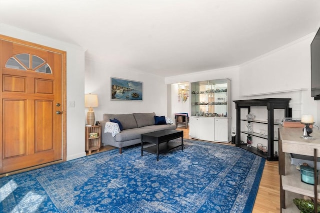 living area with crown molding and wood finished floors
