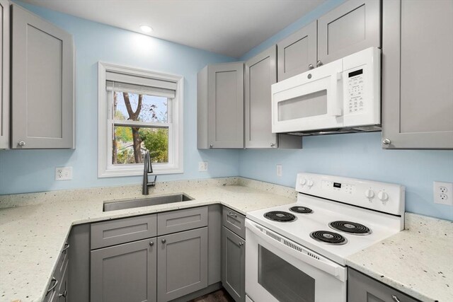 14 Melinda Ln, Easthampton, MA 01027 - kitchen with white appliances, light stone countertops, gray cabinetry, and a sink