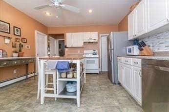 kitchen featuring appliances with stainless steel finishes, white cabinets, under cabinet range hood, and ceiling fan