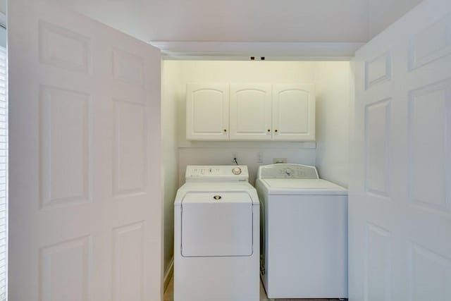 clothes washing area with cabinet space and independent washer and dryer
