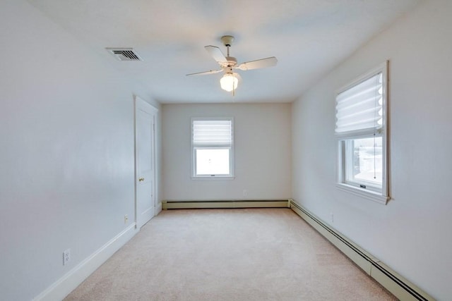 carpeted empty room with baseboard heating, ceiling fan, and baseboards