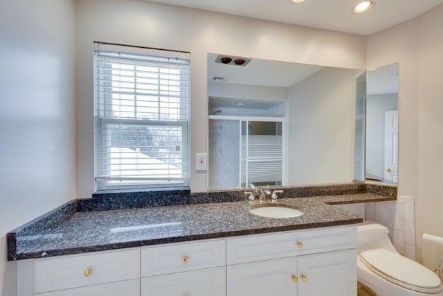 bathroom with healthy amount of natural light, toilet, a shower stall, vanity, and recessed lighting