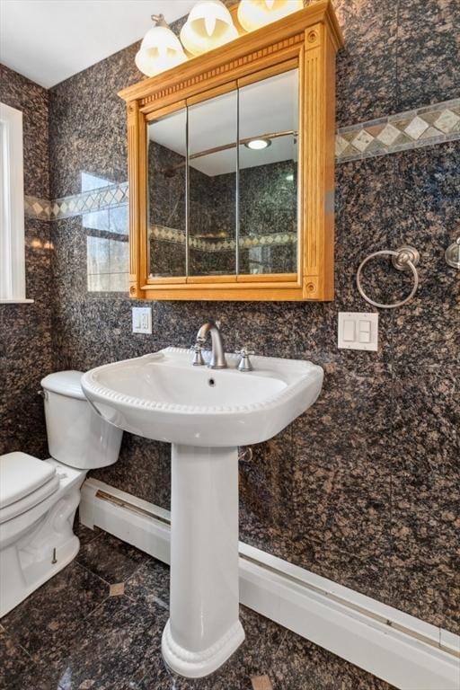 bathroom featuring sink, tile walls, baseboard heating, and toilet