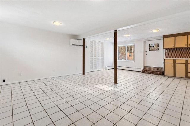 basement with light tile patterned floors, a baseboard radiator, and a wall unit AC