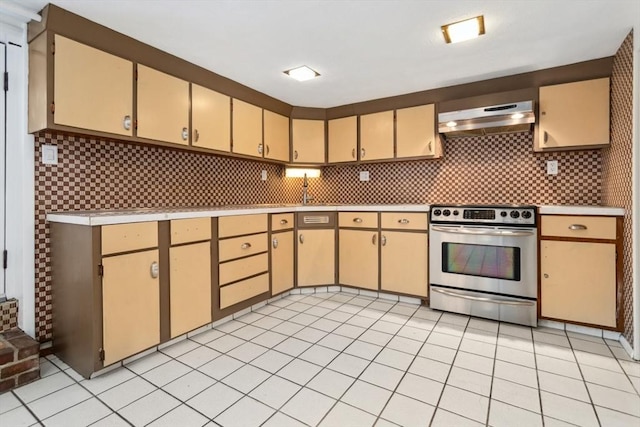 kitchen featuring light brown cabinetry, light tile patterned floors, stainless steel stove, and decorative backsplash