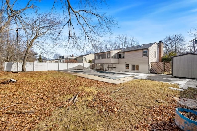 rear view of property featuring a sunroom, a swimming pool, and a patio