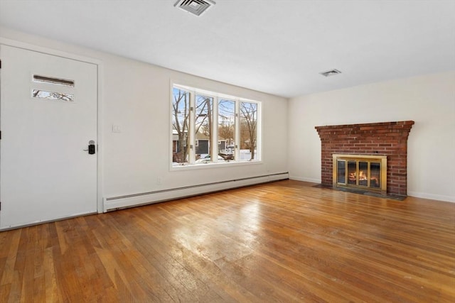 unfurnished living room with hardwood / wood-style flooring, a baseboard radiator, and a fireplace