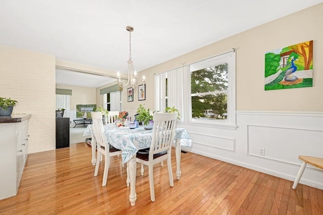 dining space with a notable chandelier and light hardwood / wood-style flooring