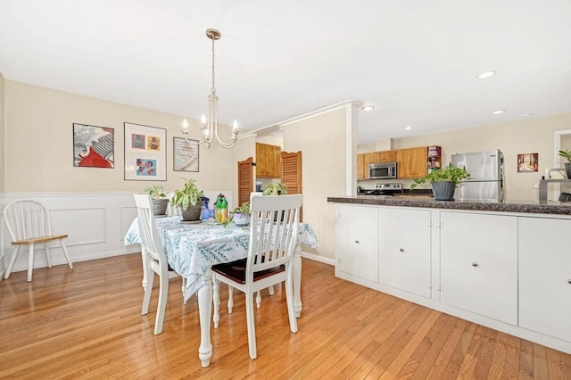 dining space with a chandelier and light hardwood / wood-style floors