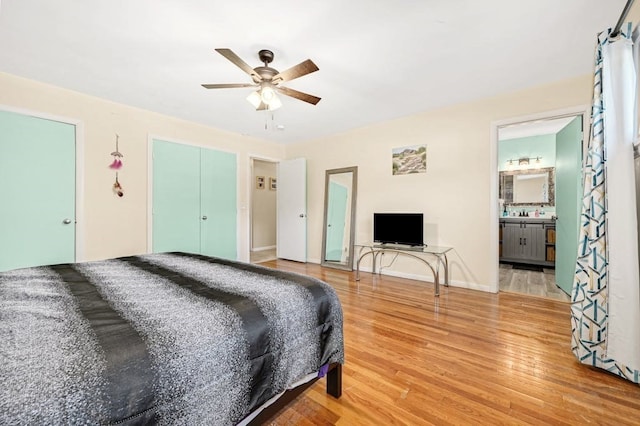 bedroom featuring light hardwood / wood-style flooring, ensuite bathroom, and ceiling fan