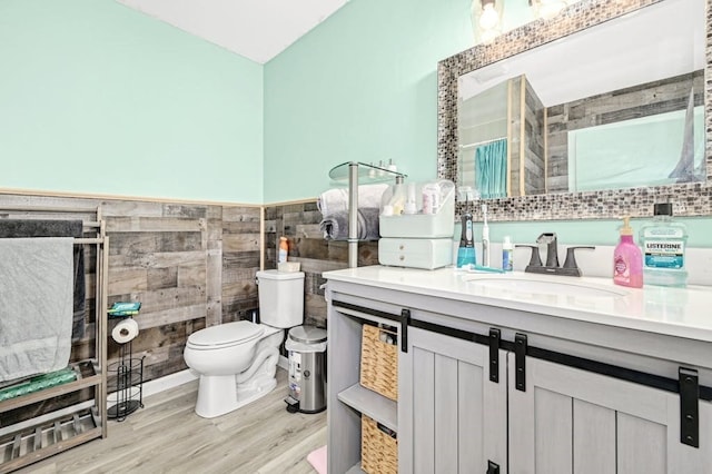 bathroom featuring vanity, toilet, tile walls, and hardwood / wood-style flooring